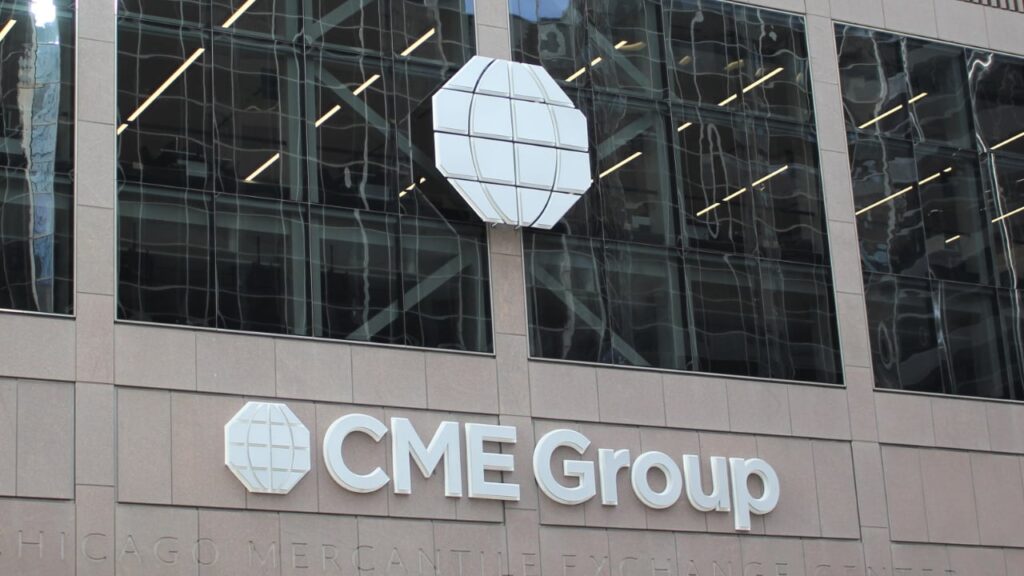 CME Group logo on a beige office building, with a blue globe emblem beside the text 'CME Group'.